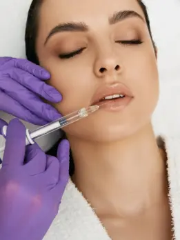 A woman aims to restore volume and achieve plumpness by receiving a facial treatment with a needle.