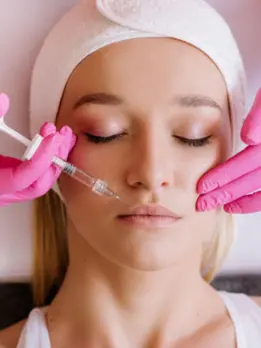 A woman aims to enhance volume and youthfulness by receiving a facial treatment with a needle.