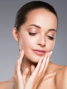 A woman focuses on smoothing wrinkles and lines with her smooth skin and clear complexion.