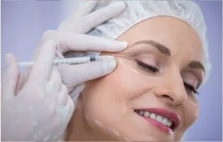 A woman receiving botox injections from a cosmetic care specialist to get wrinkle-free skin.