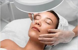 A woman receiving dermal filler injections to achieve radiant skin from a skin care specialist.