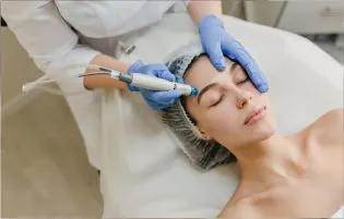 A doctor gives the best facial skin care treatments to a woman in a hospital using laser equipment.