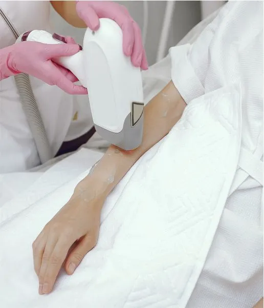 The doctor is wearing pink gloves and using the right tool to remove hair from a patient's hand.