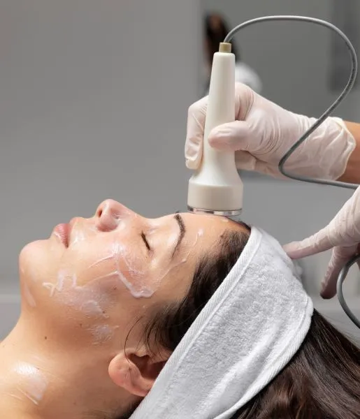 A skin care expert wearing gloves and a white coat providing a woman with a laser super facial