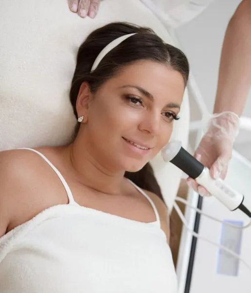 A woman getting upper lip hair removal treatment from a skin care specialist in a clinical set-up.