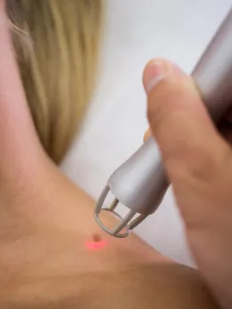 A woman applies infrared light therapy to her skin, encouraging improved personal cleanliness.