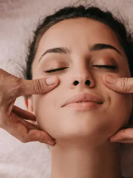 A woman is relaxing and refreshing her skin while a doctor provides a peaceful facial massage.