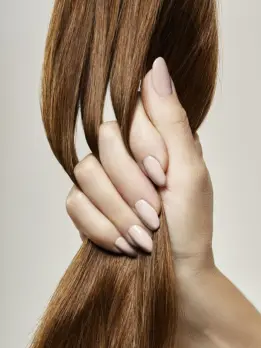 The visual of a woman embracing her long, beautiful brown hair affectionately is quite expressive.