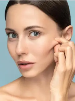 A woman using skin products to encourage the synthesis of more collagen for younger-looking skin.