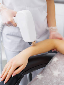 A nurse in a white outfit gives body care therapy to a woman's hand using the proper instruments