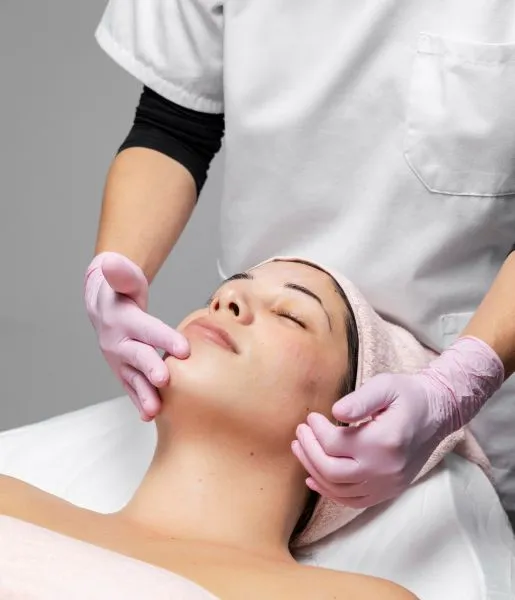 A woman is getting skin lighting therapy from a specialist who is treating her with the proper tool